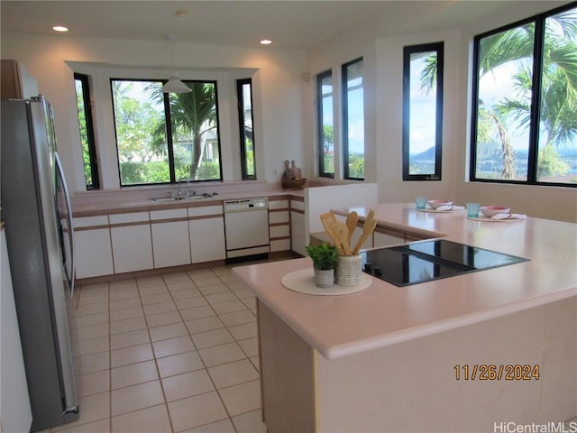 kitchen featuring stainless steel refrigerator, sink, white cabinets, white dishwasher, and black electric cooktop