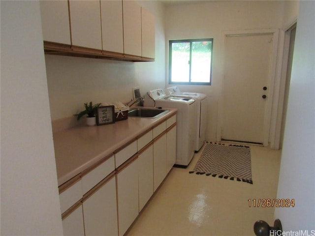 laundry room featuring cabinets, washing machine and dryer, and sink