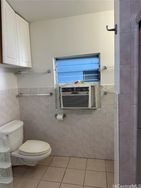 bathroom featuring toilet, tile patterned floors, tile walls, and cooling unit