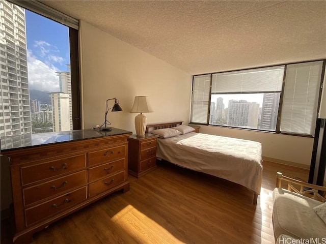 bedroom with a textured ceiling and hardwood / wood-style flooring