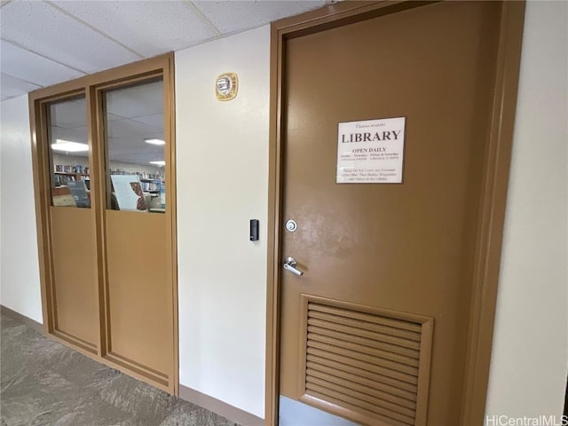 hallway with a paneled ceiling