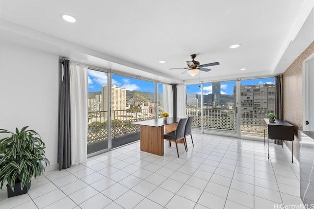 tiled dining room featuring ceiling fan, a healthy amount of sunlight, and a wall of windows