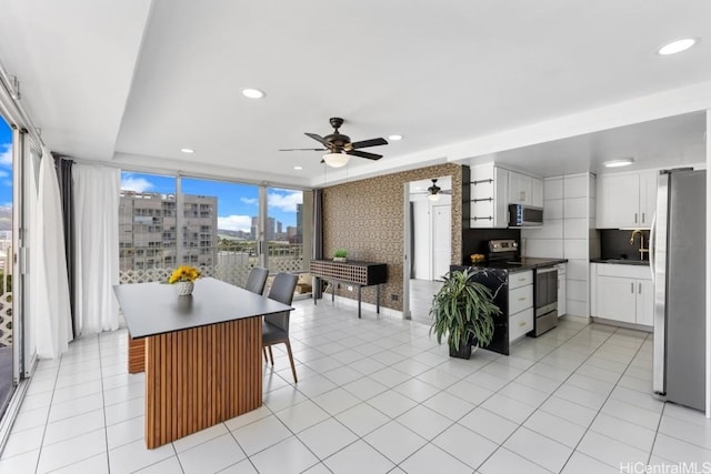 kitchen with white cabinets, stainless steel appliances, kitchen peninsula, and sink