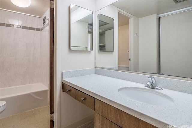 full bathroom featuring toilet, vanity, and tiled shower / bath