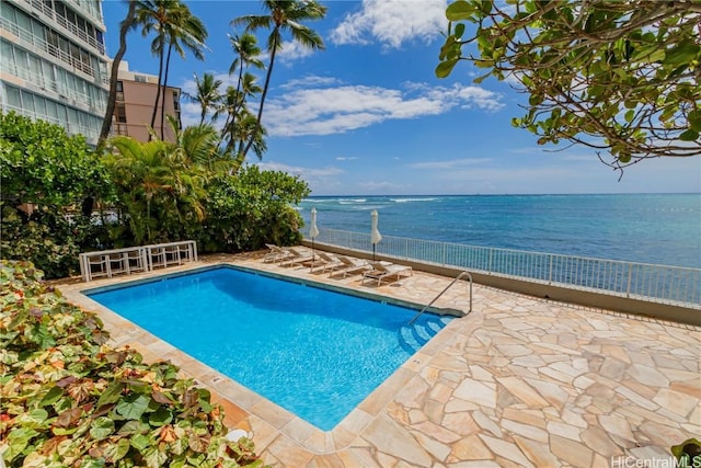 view of swimming pool with a water view and a patio