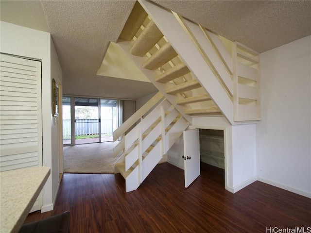 stairs featuring wood-type flooring and a textured ceiling