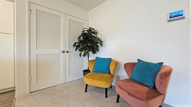 sitting room featuring light carpet