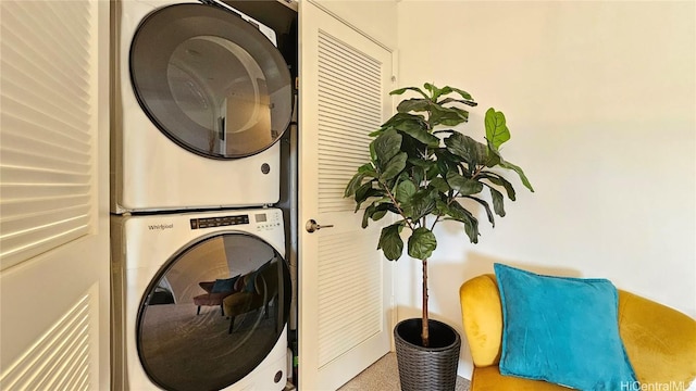 clothes washing area with stacked washing maching and dryer