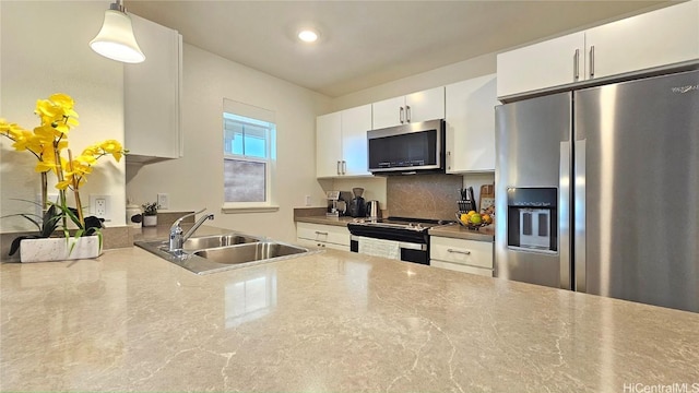 kitchen featuring appliances with stainless steel finishes, decorative backsplash, hanging light fixtures, white cabinets, and sink