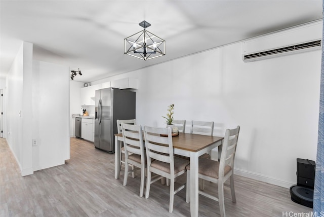 dining room featuring an inviting chandelier, light hardwood / wood-style floors, and an AC wall unit