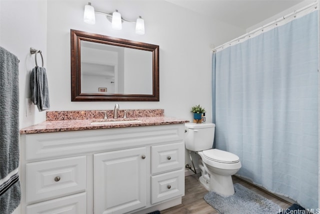 bathroom featuring toilet, vanity, and hardwood / wood-style flooring