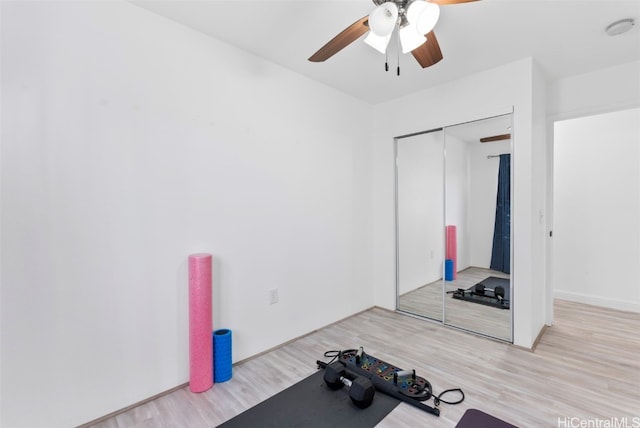 exercise room featuring ceiling fan and light wood-type flooring