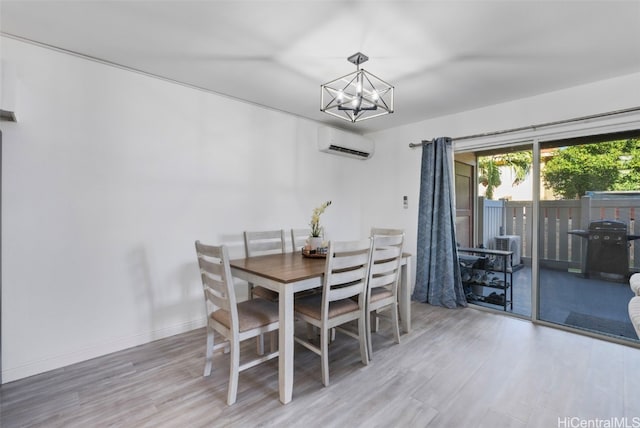 dining space featuring wood-type flooring, a wall mounted air conditioner, and an inviting chandelier