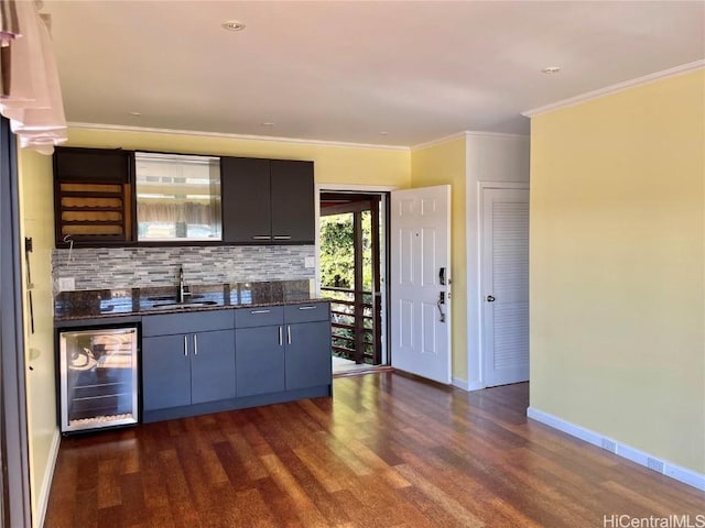 kitchen featuring dark wood-type flooring, crown molding, sink, decorative backsplash, and beverage cooler