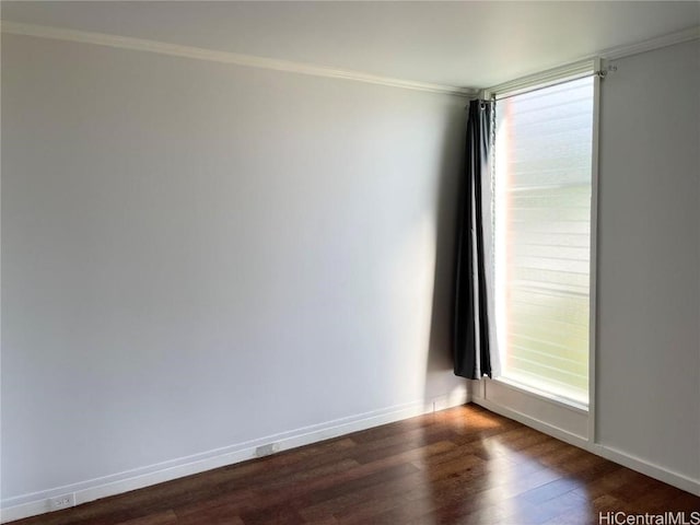 empty room with dark hardwood / wood-style flooring and ornamental molding