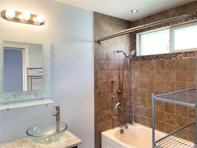 bathroom with vanity and tiled shower / bath