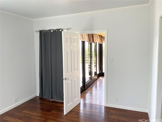 spare room featuring crown molding and dark wood-type flooring