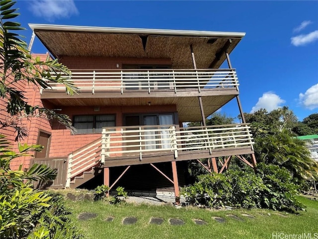 rear view of property with a balcony and a wooden deck