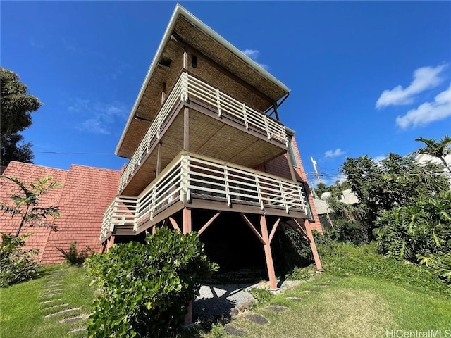 rear view of house featuring a deck and a yard