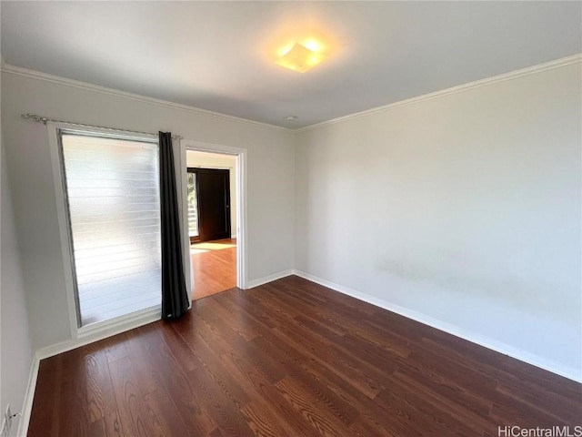 spare room featuring dark hardwood / wood-style floors and crown molding