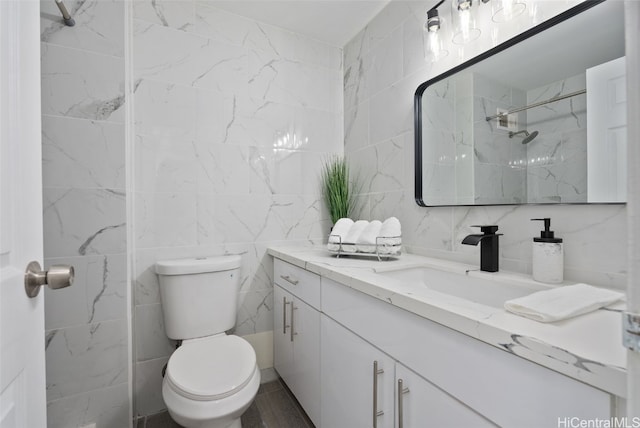 bathroom featuring a shower, vanity, toilet, and tile walls