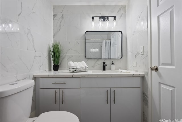 bathroom featuring vanity, curtained shower, toilet, and tile walls