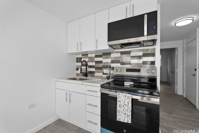 kitchen with white cabinets, appliances with stainless steel finishes, decorative backsplash, and sink