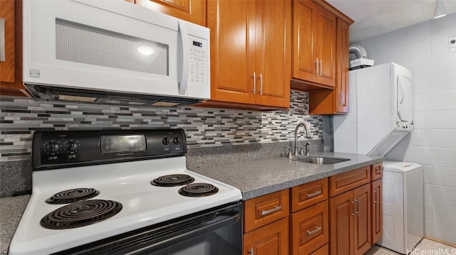 kitchen featuring decorative backsplash, white appliances, and sink