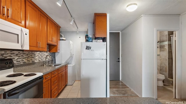 kitchen featuring white appliances, rail lighting, sink, decorative backsplash, and light tile patterned flooring