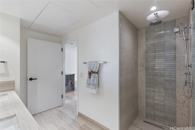 bathroom featuring a tile shower and vanity