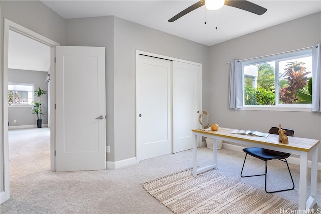 carpeted home office featuring ceiling fan