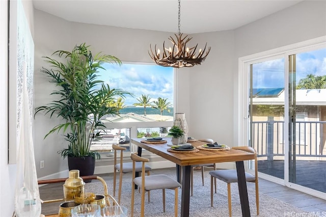 dining room featuring baseboards, wood finished floors, and a notable chandelier