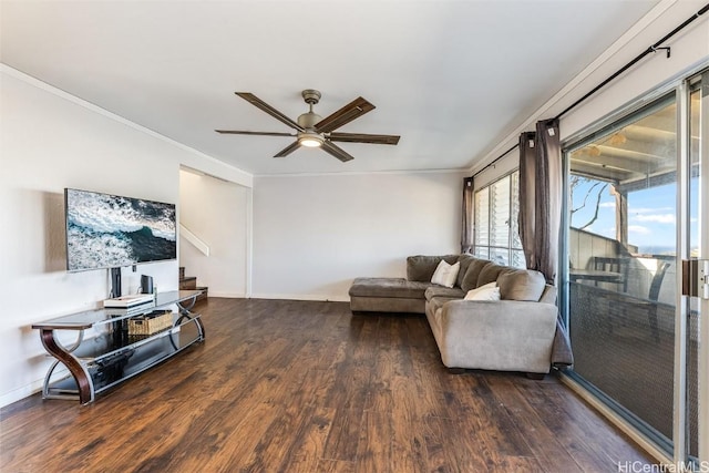 living area with crown molding, ceiling fan, wood finished floors, baseboards, and stairs