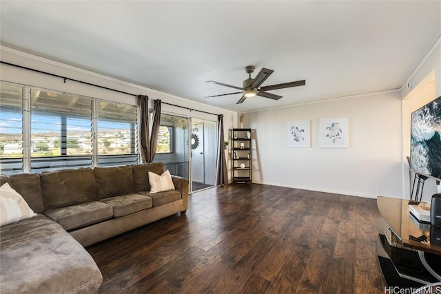 living room with ornamental molding, a ceiling fan, baseboards, and wood finished floors