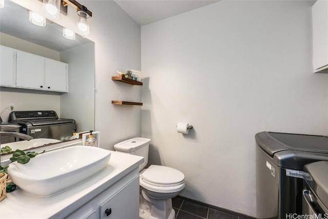 bathroom featuring toilet, vanity, tile patterned floors, and separate washer and dryer