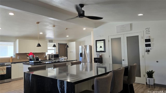 kitchen featuring decorative backsplash, pendant lighting, appliances with stainless steel finishes, and a center island