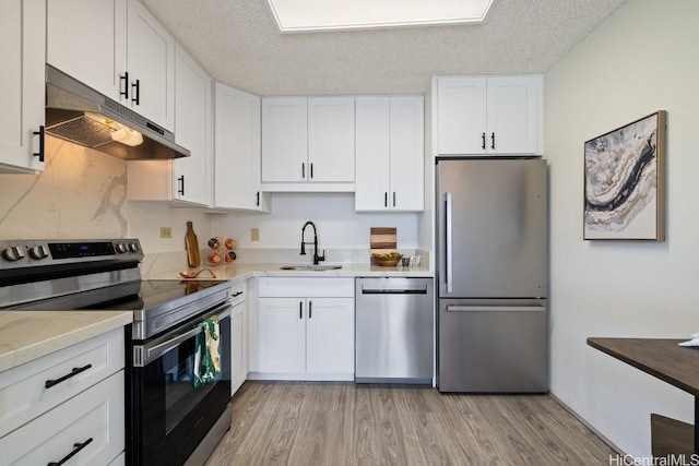 kitchen with a textured ceiling, white cabinetry, and stainless steel appliances