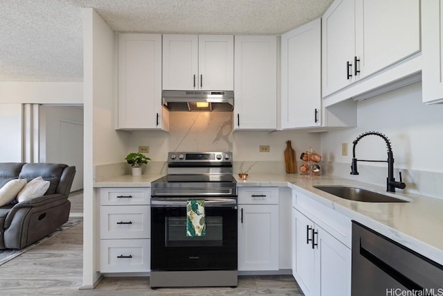 kitchen featuring light wood-type flooring, stainless steel appliances, white cabinetry, and sink