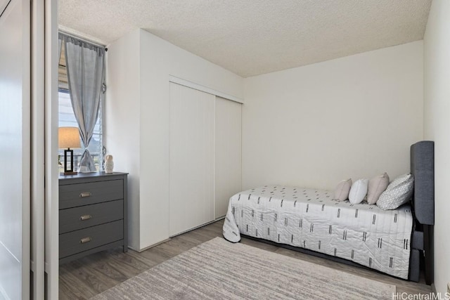 bedroom featuring a textured ceiling, light hardwood / wood-style floors, and a closet