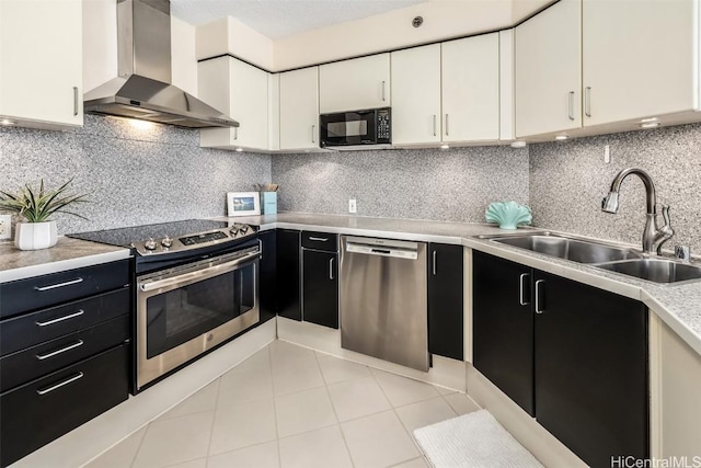 kitchen featuring stainless steel appliances, white cabinetry, tasteful backsplash, and wall chimney exhaust hood