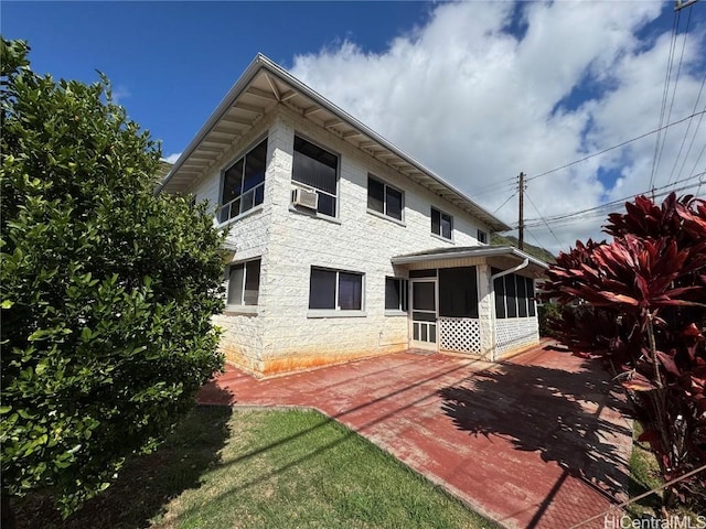 back of house featuring a patio area, a sunroom, and cooling unit