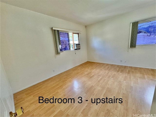 empty room with cooling unit and light wood-type flooring