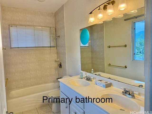 full bathroom featuring tile patterned flooring, vanity, tiled shower / bath combo, and toilet