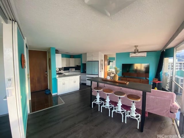 kitchen featuring a textured ceiling, ceiling fan, white refrigerator, dark hardwood / wood-style floors, and white cabinetry