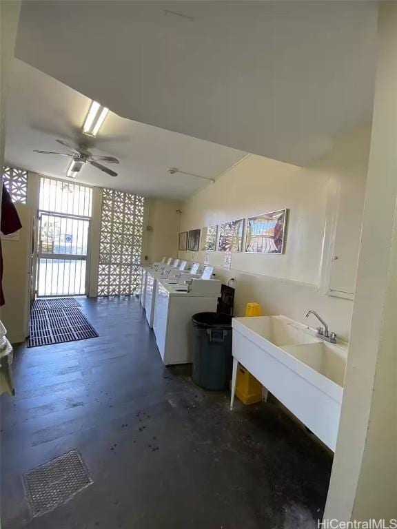 interior space featuring washing machine and dryer, ceiling fan, and sink