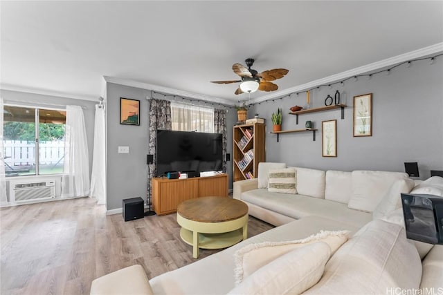 living room with ceiling fan, light wood-type flooring, ornamental molding, and a healthy amount of sunlight