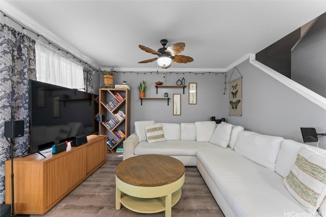 living room featuring crown molding, wood-type flooring, and ceiling fan