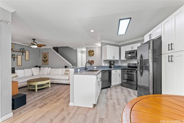 kitchen with sink, white cabinetry, black appliances, and crown molding