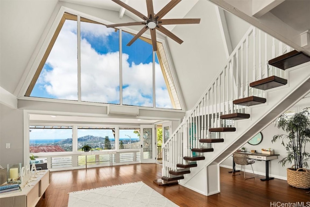 stairs featuring hardwood / wood-style flooring, high vaulted ceiling, ceiling fan, and an AC wall unit