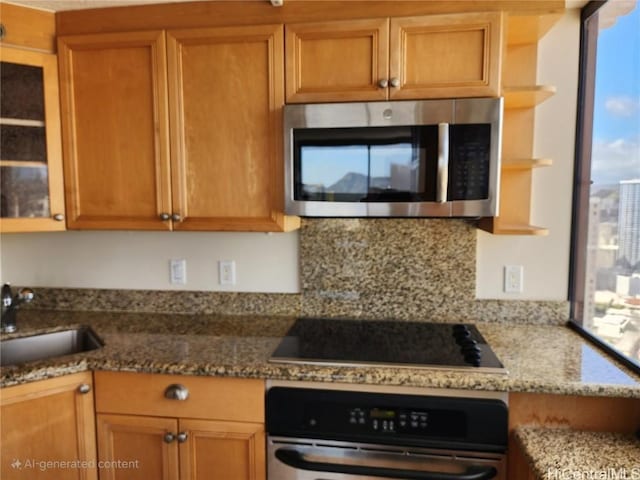 kitchen with sink, black electric cooktop, oven, and stone countertops